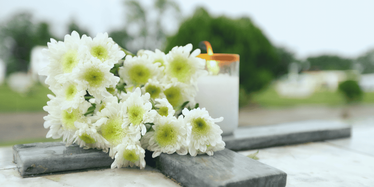 cross on tomb with flowers